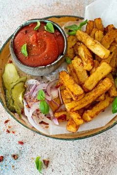 Fried potatoes (deep fried) with herbs and spices, ketchup, pickles Stock Photos