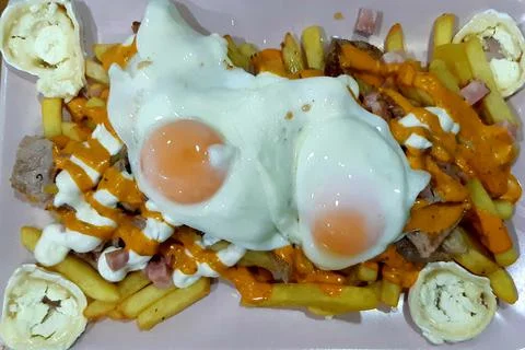 Fried potatoes with fried eggs. 库存照片