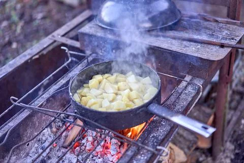 Fried potatoes on an open fire Foto stock