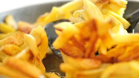 Fried potatoes.Appetizing fried potatoes.Black spatula flips potatoes in a pan Stock Footage 236094643