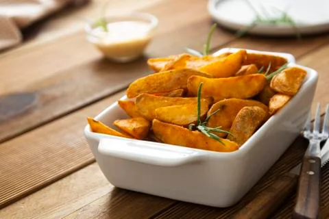 Fried potatos chips in white dish. Homemade roasted potatoes chips. Wooden, r Stock Photos