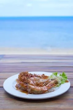 The fried prawns with tamarind sauce in plate with beach background Stock Photos