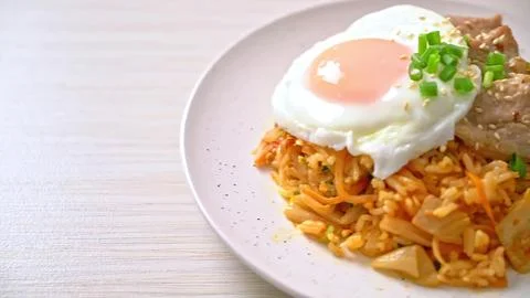 Fried rice with fried egg and green onion on white plate Stock Photos