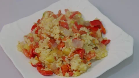 Fried rice made with red bell peppers, onions, potatoes, carrots, and tomatoes Stock Footage 318656788