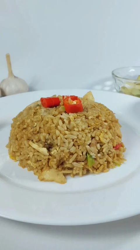 Fried rice is placed on a rotating white plate. Vertical view, front view. Stock Footage 329376213