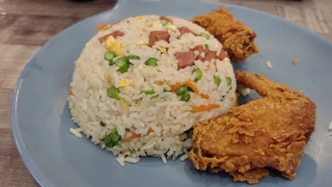 Fried rice served with crispy, flavourful fried chicken wings. Stock Footage 301421875