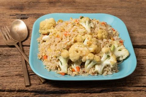 Fried rice with vegetable and egg in plate on wood background. Stock Photos