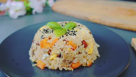 Fried rice with vegetables and egg served on black plate indoors Vidéo 342861320