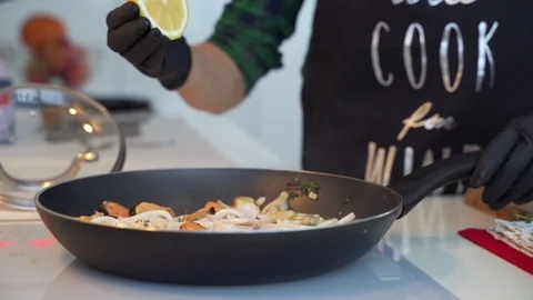 Fried rings of squid with herbs and onion in the frying pan. Stock Footage 102211287