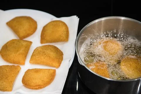 Fried rissois are lifted from hot oil and drained on paper towels Stock Photos
