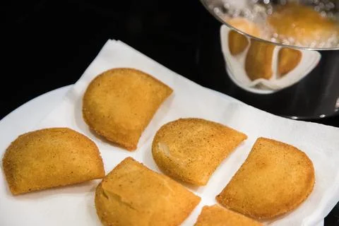 Fried rissois are lifted from hot oil and drained on paper towels Stock Photos