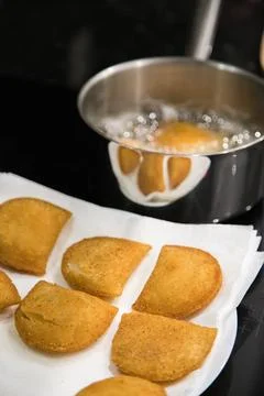Fried rissois are lifted from hot oil and drained on paper towels Stock Photos