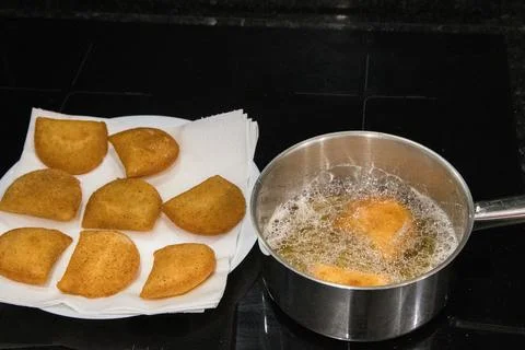 Fried rissois are lifted from hot oil and drained on paper towels Stock Photos
