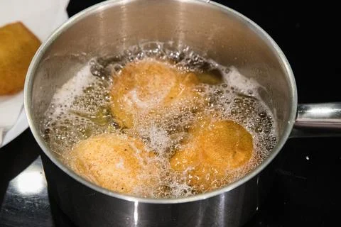 Fried rissois are lifted from hot oil and drained on paper towels Stock Photos