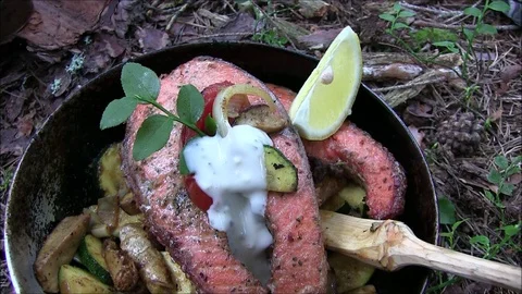 Fried salmon in a camping pan Stock Footage 129972330