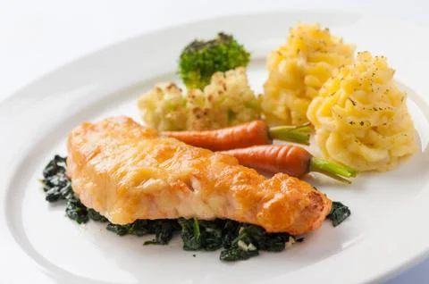 Fried salmon with spinach Stock Photos