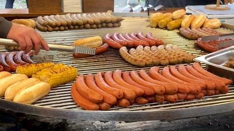 Fried sausages, buns and corn on the grill. Street food. Stock Footage 149942299