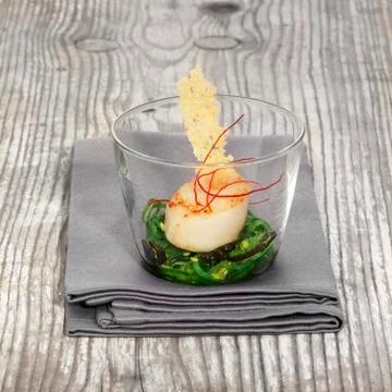 Fried scallops on an algae medley Stock Photos