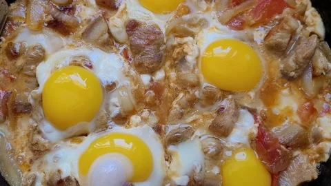 Fried scrambled eggs with bacon in a pan Stock Footage 195938698