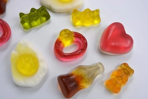 Fried scrambled eggs, bottle cola, colored bears, rings with stones, pink heart Stock Photos