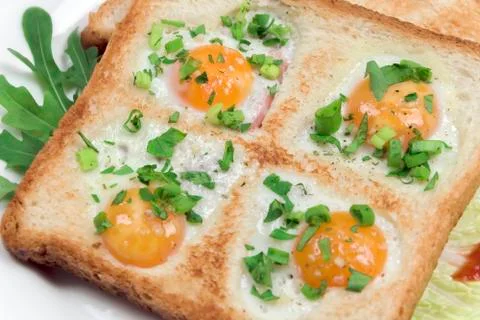 Fried scrambled quail eggs in bread with fresh vegetables on a plate, closeup Foto stock