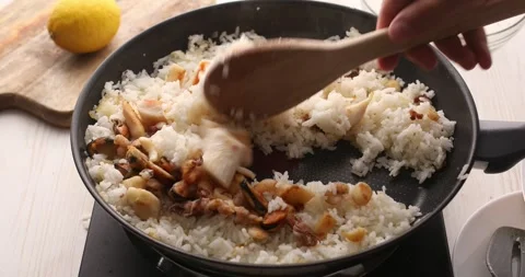 Fried seafood is mixed with rice with a spatula in a frying pan. Stock Footage 249526825