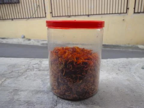 Fried shallots with jar container,  roadside concrete floor background Stock-Fotos