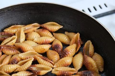 Fried shell pasta in a pan Foto stock
