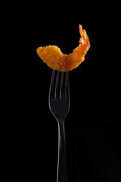 Fried shrimp on a fork. On a dark background. Stock Photos