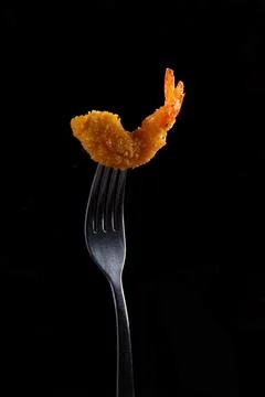 Fried shrimp on a fork. On a dark background. Stock Photos