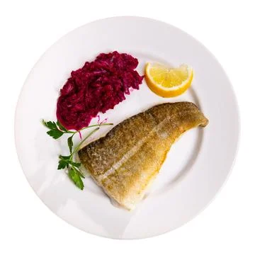 Fried slice of cod fillet served with stewed beetroot. Stock Photos