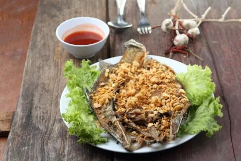 Fried Snapper with Garlic and Pepper on wood table. Stock Photos