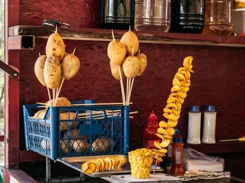 Fried spiral spring potato chips on stick with corn cup, Georgian street fo.. Stock Photos
