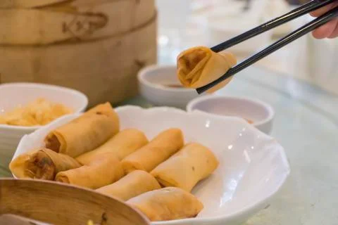 Fried spring rolls are grab by chopsticks black Stock Photos