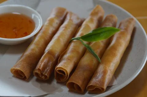 Fried spring rolls filled with tea leaves on a white plate Foto stock