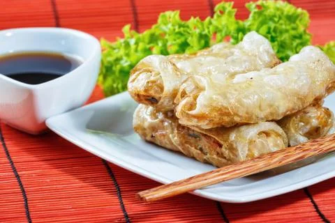 Fried spring rolls on red bamboo mat Stock Photos