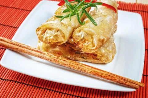 Fried spring rolls on red bamboo mat 스톡 사진