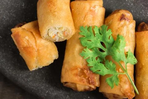 Fried Spring Rolls Stacked on black slate plate on wooden Stock Photos