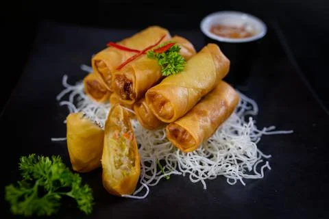 Fried spring rolls with sweet chilli sauce and crispy noodles on a plate Stock Photos