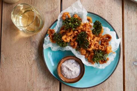 Fried squid with kale on table with drink, overhead view Stock Photos