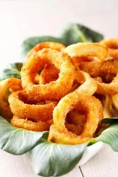 Fried squid rings breaded with lemon on a plate Stock Photos