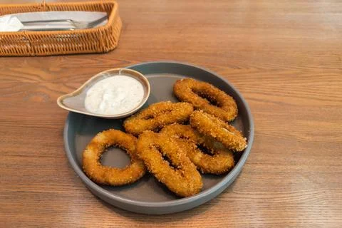 Fried squid rings in crispy breading with tartar sauce Stock Photos