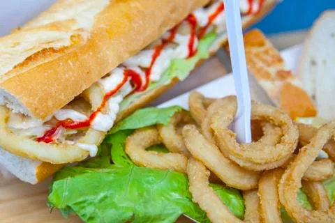 Fried squid rings displayed on bread roll and cardbox Stock Photos