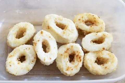Fried squid rings in plastic container Stock Photos
