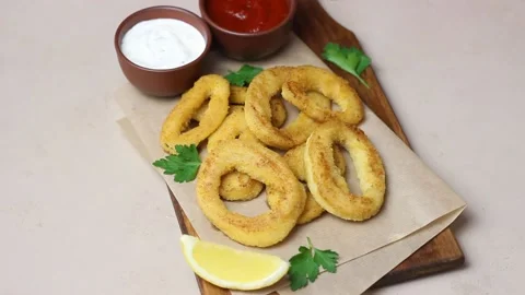 Fried squid rings with two sauces, lemon and herbs. Fast food. Appetizer. Stock Footage 168729043