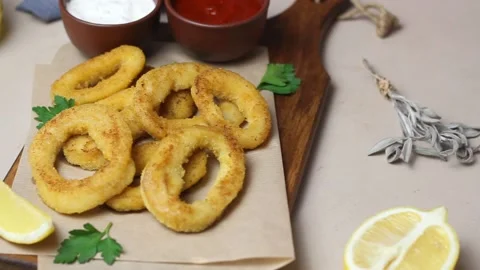 Fried squid rings with two sauces, lemon and herbs. Fast food. Appetizer. Stock Footage 168729044