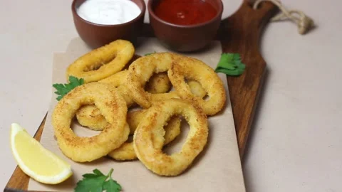 Fried squid rings with two sauces, lemon and herbs. Fast food. Appetizer. Stock Footage 168729045