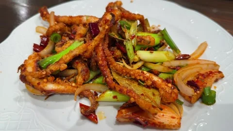 Fried squid with spicy red peppers, onions, and bay leaves. Spicy Asian dish. Stock Footage 320722389