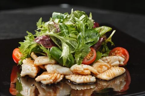 Fried squid with vegetable salad Stock Photos