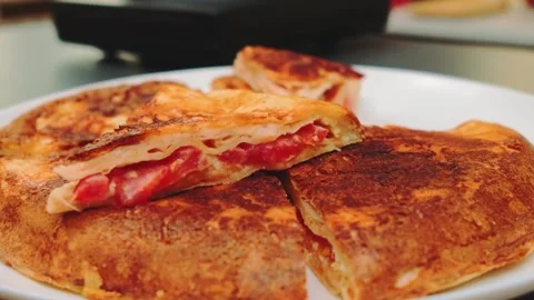Fried stuffed flatbread with tomato and cheese on white plate indoors Stock Footage 342888318